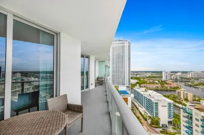 a balcony with a table and chairs and a view of a city at Hyde Resort Beachfront Condo #1904 - GORGEOUS 2BD & 2BA APT WITH OCEAN VIEW in Hollywood
