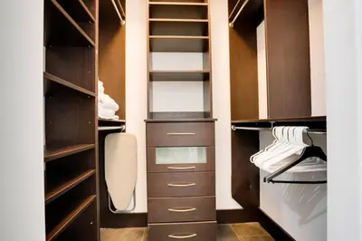 a walk in closet with wooden cabinets and shelves at Best of Brickell's Luxury Suite with Pool and Gym in Miami