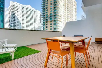 a table and chairs on a balcony with tall buildings at Best of Brickell's Luxury Suite with Pool and Gym in Miami