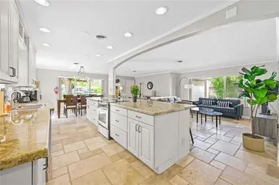 a kitchen with white cabinets and a living room at Home wpool by PMI unit 332 in Fort Lauderdale