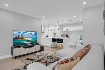 a living room with a white couch and a tv at Casa la Miami - Central location Villa with Pool & Gym in Miami