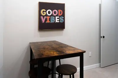 a table with two stools and a sign on a wall at Elegant Miami Apartment East Little Havana / Free Parking in Miami