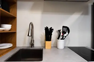 a kitchen counter with a sink and utensils at Elegant Miami Apartment East Little Havana / Free Parking in Miami