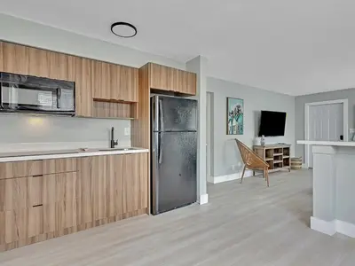 a kitchen with wooden cabinets and a stainless steel refrigerator at Dania Beach Christmas Retreat Museums Food in Dania Beach