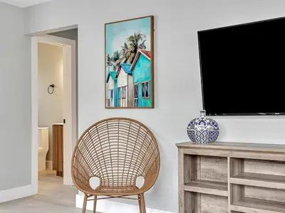 a living room with a television and a rattan chair at Dania Beach Christmas Retreat Museums Food in Dania Beach