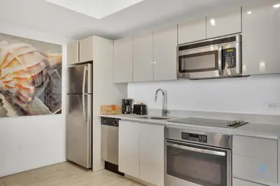a kitchen with white cabinets and stainless steel appliances at Spectacular Balcony - Near Beach - Gym - Pool in Hallandale Beach