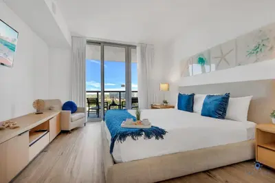 a large bedroom with a large bed and a desk at Spectacular Balcony - Near Beach - Gym - Pool in Hallandale Beach