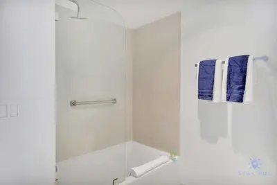 a bathroom with a shower with a blue towel at Amazing Pool - Gym - Complementary Shuttle in Hallandale Beach