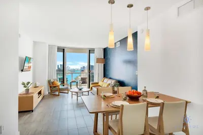 a dining room and living room with a table and chairs at Infinite View with Balcony, Amazing Pool, Gym in Hallandale Beach