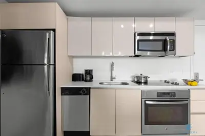 a kitchen with a stainless steel refrigerator and a microwave at Infinite View with Balcony, Amazing Pool, Gym in Hallandale Beach