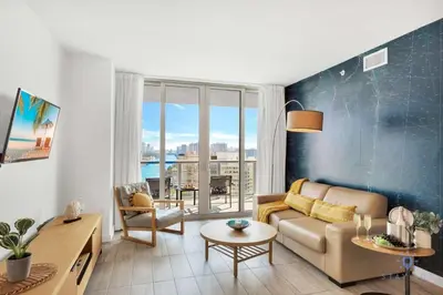a living room with a couch and a table at Infinite View with Balcony, Amazing Pool, Gym in Hallandale Beach