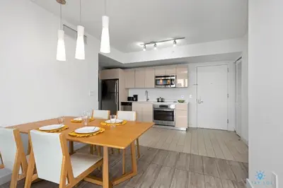 a kitchen and dining room with a wooden table and chairs at Infinite View, Balcony with Gym and Amazing Pool in Hallandale Beach