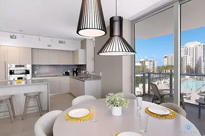 a kitchen and living room with a table and chairs at Wrap Around Balcony, Insane Amenities, Amazing Pool in Hollywood