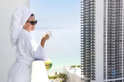 a woman taking a picture of the ocean from a building at Wrap Around Balcony, Insane Amenities, Amazing Pool in Hollywood
