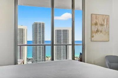a bedroom with a large window with a view of the ocean at Spacious VIP Penthouse with Ocean & Intracoastal Views, Private Entry, Resort Amenities in Hallandale Beach