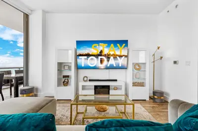a living room with a sign that reads stay today at Beachwalk Resort - PENTHOUSE IN THE SKY 3BDR and 3BA LUXURY CONDO DIRECT OCEAN VIEW in Hallandale Beach