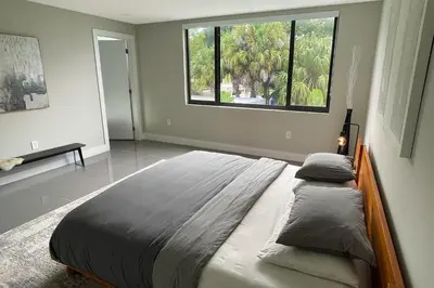 a bedroom with a large bed with a large window at Topo Encanto - Designer Villa, Sundrenched Paradise! in Fort Lauderdale
