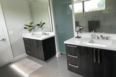 a bathroom with two sinks and a mirror at Topo Encanto - Designer Villa, Sundrenched Paradise! in Fort Lauderdale