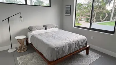 a bedroom with a bed and a large window at Topo Encanto - Designer Villa, Sundrenched Paradise! in Fort Lauderdale