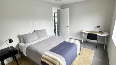 a white bedroom with a bed and a desk at Topo Encanto - Designer Villa, Sundrenched Paradise! in Fort Lauderdale