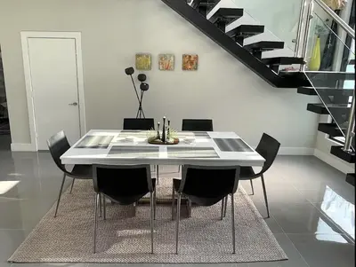 a dining room with a white table and black chairs at Topo Encanto - Designer Villa, Sundrenched Paradise! in Fort Lauderdale