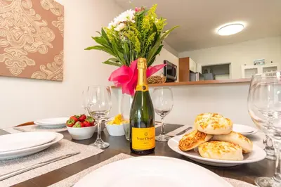 a table with a bottle of wine and a vase of flowers at Marina Bay 406 in Miami Beach