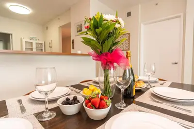 a table with a vase of flowers and fruit on it at Marina Bay 406 in Miami Beach