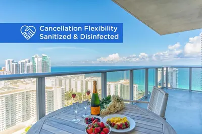 a table with food and wine on a balcony with the ocean at Hyde Beach House 2601 in Hollywood