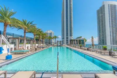 a swimming pool with palm trees and buildings at Hyde Beach House 2601 in Hollywood