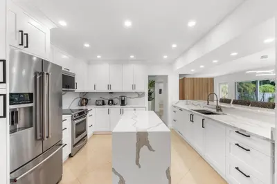a kitchen with white cabinets and stainless steel appliances at Spacious Modern Mansion w Pool & Sauna in Hollywood close to Beach in Hollywood