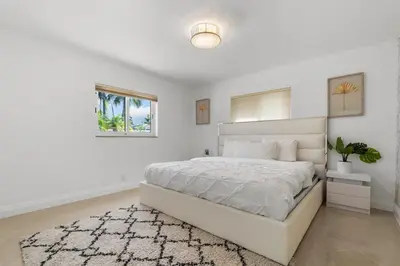 a white bedroom with a white bed and a rug at Spacious Modern Mansion w Pool & Sauna in Hollywood close to Beach in Hollywood