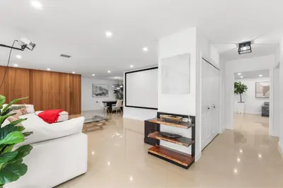 a living room with a white couch and a large screen at Spacious Modern Mansion w Pool & Sauna in Hollywood close to Beach in Hollywood