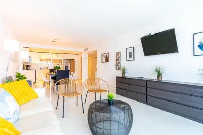a living room with a couch and a tv on a wall at Ocean Reserve 1006 in Miami Beach