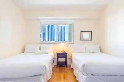 two twin beds in a room with a window at Golden Bay 703 in Miami Beach