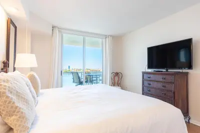 a bedroom with a bed and a flat screen tv at Golden Bay 703 in Miami Beach
