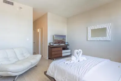 a white bedroom with a white bed and a couch at Ocean Reserve PH6 in Miami Beach