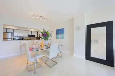 a dining room with a glass table and white chairs at Ocean Reserve 1524 in Miami Beach