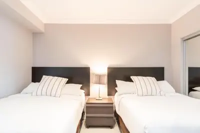 a bedroom with two beds and a lamp on a night stand at Golden Bay 808 in Miami Beach