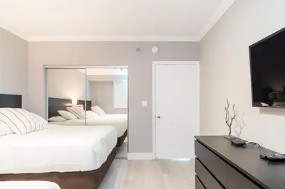 two beds in a bedroom with a tv and a dresser at Golden Bay 808 in Miami Beach