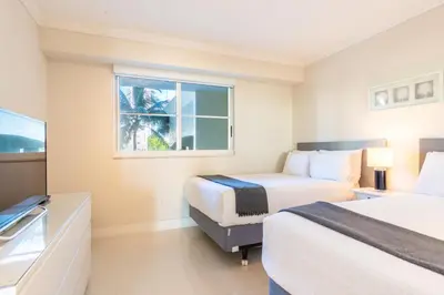 a hotel room with two beds and a window at Golden Bay 406 in Miami Beach