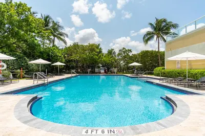 a swimming pool at a resort with chairs and umbrellas at Golden Bay 406 in Miami Beach