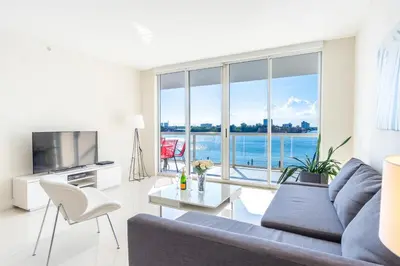 a living room with a couch and a large window at Golden Bay 406 in Miami Beach