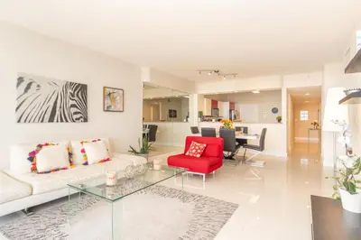 a living room with a couch and a red chair at Golden Bay 408 in Miami Beach