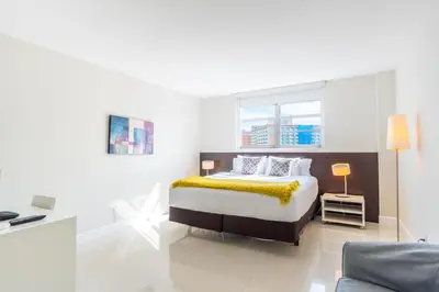 a bedroom with a bed with a yellow blanket on it at Ocean Reserve 725 in Miami Beach