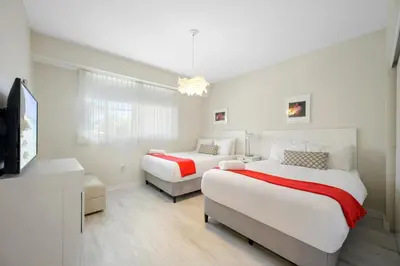 a bedroom with two beds and a television in it at Golden Bay 506 in Miami Beach
