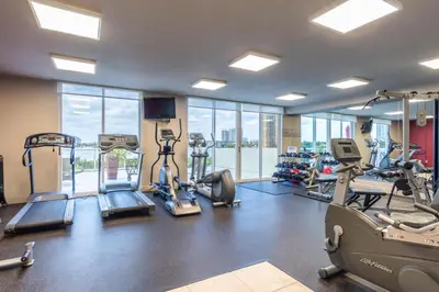 a gym with treadmills and elliptical machines at Golden Bay 506 in Miami Beach