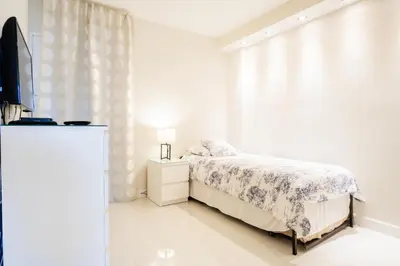 a white bedroom with a bed and a window at Ocean Reserve 927 in Miami Beach