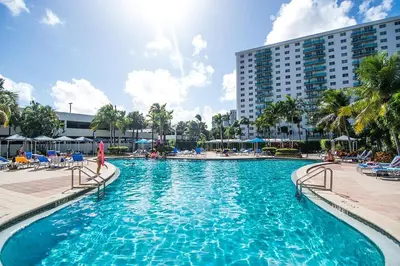 a large swimming pool with chairs and a building at Ocean Reserve 927 in Miami Beach