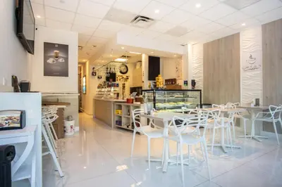 a restaurant with white tables and white chairs at Ocean Reserve 1112 in Miami Beach