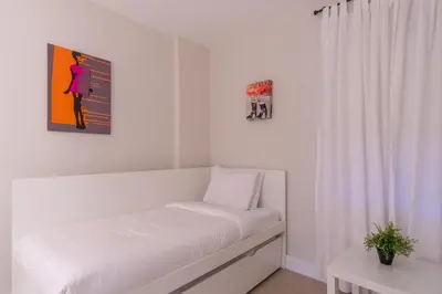 a white room with a bed and a painting on the wall at Ocean Reserve 1404 in Miami Beach
